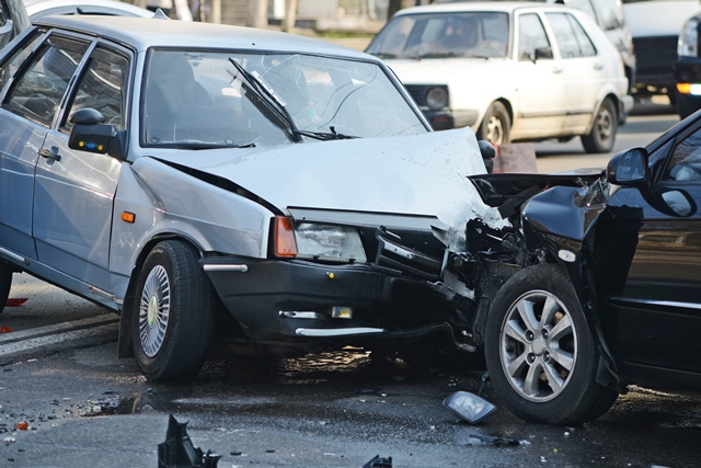 A photo of two cars in a front end accident