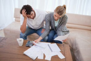 Chapter 7 Bankruptcy Lawyer Arlington TX with a stressed looking couple going through a pile of bills
