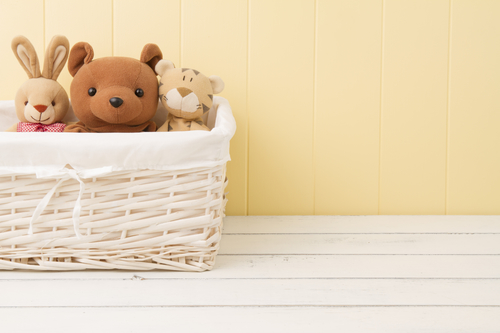 Stuffed animal toys in a basket on the floor